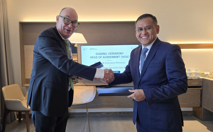 Pupuk Indonesia president director Rahmad Pribadi (right) and BFI CEO Harri Kiiski shake hands on April 23, 2024, after signing a heads of Agreement (HoA) in Abu Dhabi regarding the development of urea and ammonia.