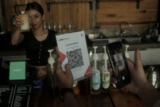 A customer scans a Quick Response Indonesia Standard (QRIS) code to settle a transaction on April 24, 2024, at a coffee shop in Sukabumi, West Java.