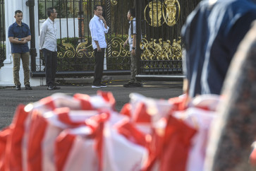 President Joko “Jokowi“ Widodo (third left) talks with Presidential Secretariat head Heru Budi Hartono (left) during a food disbursement event at the State Palace in Jakarta on April 8, 2024.