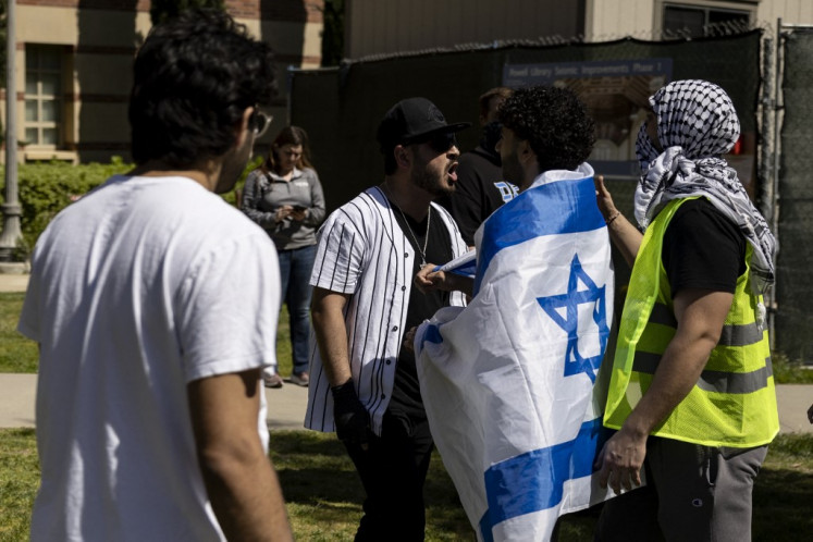 A pro-Israeli demonstrator (left) is separated by another one as he argues with a pro-Palestinian demonstrator on the campus of the University of California Los Angeles (UCLA), in Los Angeles on April 28, 2024. 