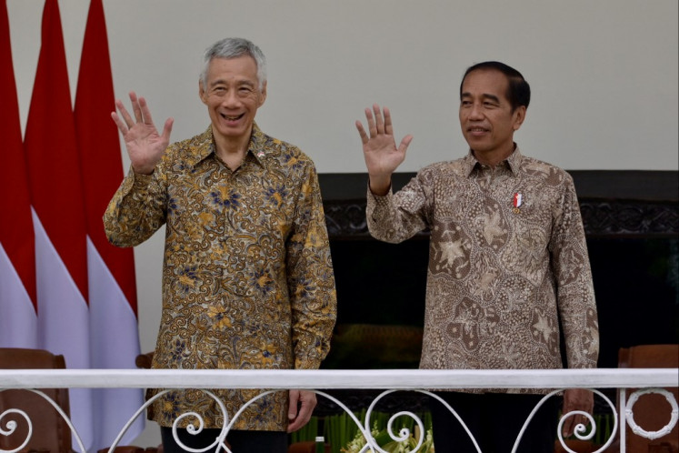President Joko “Jokowi“ Widodo (right) and Singaporean Prime Minister Lee Hsien Loong (left) wave to photographers during their meeting at Bogor Presidential Palace in West Java on April 29, 2024. 