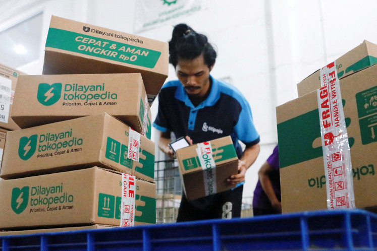 An employee packs goods at GoTo's e-commerce unit Tokopedia's warehouse in Jakarta on Aug. 31, 2022.