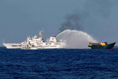 FILE PHOTO: Chinese Coast Guard vessels fire water cannons on March 5, 2024, toward Philippine resupply vessel Unaizah May 4 on a resupply mission at the Second Thomas Shoal in the South China Sea. REUTERS/Adrian Portugal/File Photo