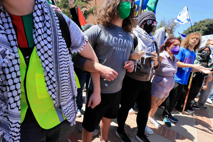 Protesters in support of Palestinians in Gaza lock arms as pro-Israel counter-protesters gather nearby, during demonstrations amid the ongoing conflict between Israel and the Palestinian Islamist group Hamas, at the University of California Los Angeles (UCLA) in Los Angeles, California, US April 28, 2024. 