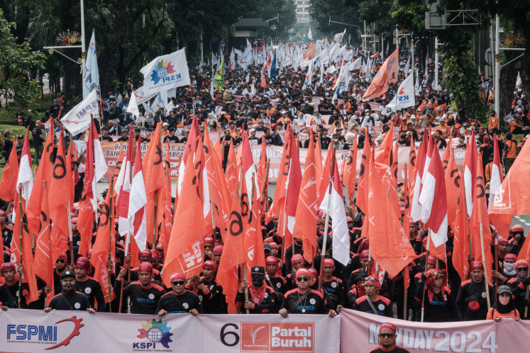 Demonstrators march with flags and
banners during a rally in Jakarta on May 1, 2024
commemorating International Workers’ Day. 