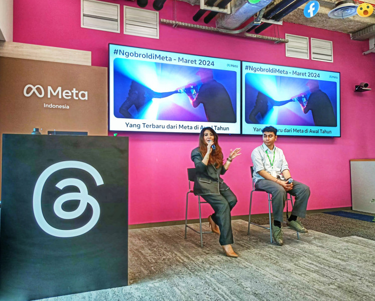 Meta director for global partnerships in Southeast Asia Revie Sylviana (left) talks about new features on Meta platforms while Cretivox junior art director Ridho Andy Fadillah (right) looks on during a press conference in Jakarta on March 27, 2024. 