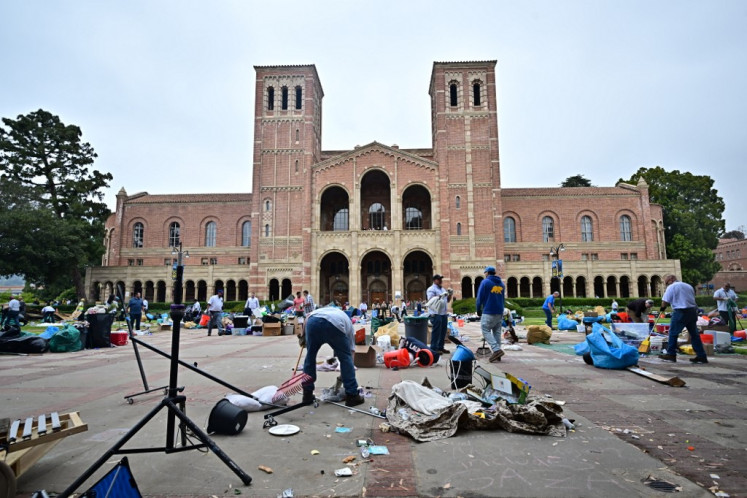 Workers clean up the University of California, Los Angeles (UCLA) campus after police evicted pro-Palestinian students, in Los Angeles, California, early on May 2, 2024. 