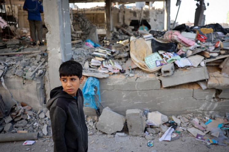 A Palestinian child stands in front of a building destroyed by Israeli bombing in Rafah in the southern Gaza Strip on May 3, 2024, amid the ongoing conflict between Israel and the Hamas movement. 