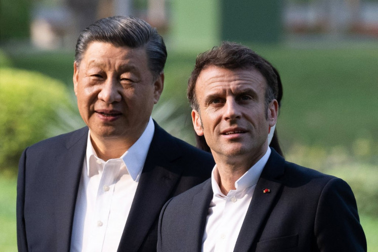 China's President Xi Jinping (left) and France's President Emmanuel Macron (right) visit the garden of the residence of the Governor of Guangdong in Guangzhou on April 7, 2023, where  XI Jinping's father XI Zhongxun lived. 