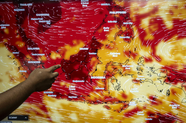 An official from the Meteorology, Climatology and Geophysics Agency (BMKG) points on May 6, 2024, to a map displaying nationwide temperature observations at the BMKG headquarters in Jakarta. The agency has said that the country's current bout of hot weather is not a heat wave, but part of an expected seasonal temperature increase.