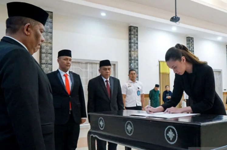 Legally Indonesian: Felicia Liana Adema (right), a child of a mixed marriage couple, signs the document of her Indonesian citizenship at the West Java office of the Law and Human Rights Ministry in Bandung, West Java, on March 8, 2023.
