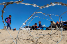 Palestinians sit to next to belongings as people flee Rafah after Israeli forces launched a ground and air operation in the eastern part of the southern Gaza city, amid the ongoing conflict between Israel and Hamas, in the southern Gaza Strip May 9, 2024. 