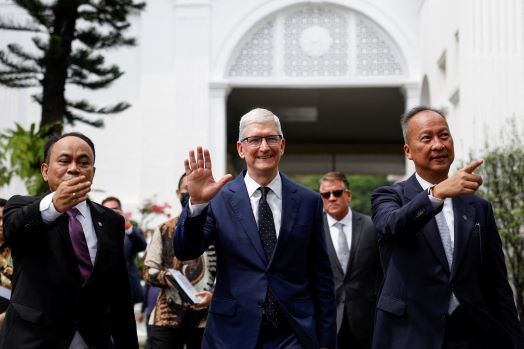 Red carpet welcome: Apple CEO Tim Cook (center), accompanied by Communications and Information Minister Budi Arie Setiadi (left) and Industry Minister Agus Gumiwang Kartasasmita, waves to journalists on April 17, 2024 after attending a meeting with President Joko “Jokowi” Widodo at the Presidential Palace.