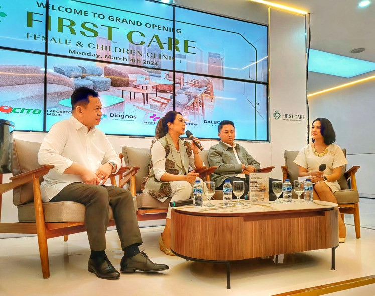 Obstetrician-gynecologist (ob-gyn) Dinda Derdameisha (second left) speaks at a talk show on women's reproductive health during the grand launch of First Care women’s and children’s clinic in South Jakarta on March 4, 2024, as the clinic’s founder Fitriyadi Kusuma (left) and CEO Pasha Fernanda Fauzi (second right) look on.