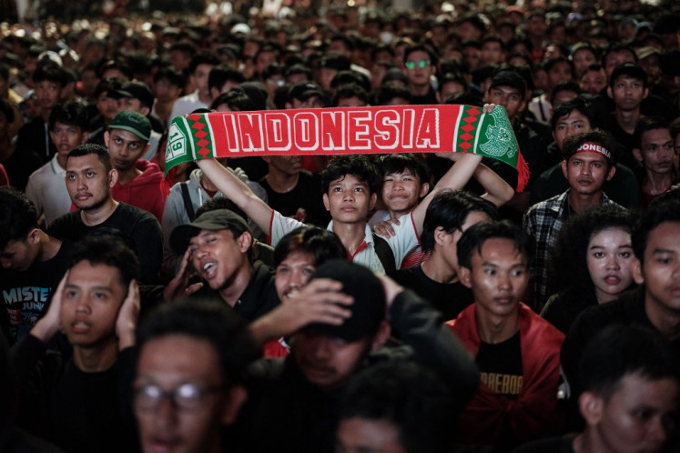 Indonesian soccer fans watch in a large screen the live broadcast of the pre-Olympic play-off match between Indonesia and Guinea for final spot in the mens Olympic soccer tournament at Paris 2024, outside the Gelora Bung Karno stadium in Jakarta on May 9, 2024.
