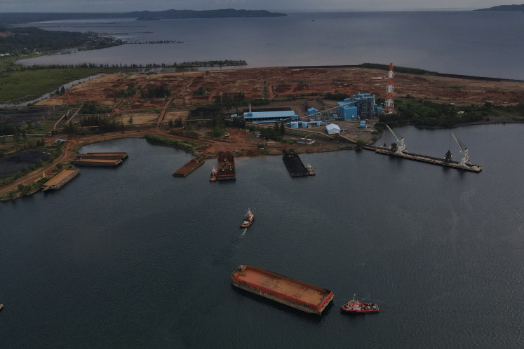 A tugboat pushes a sand barge on May 10, 2024, in the waters off the port development project of state-owned mining company PT Aneka Tambang (Antam) in Pomalaa, Southeast Sulawesi.