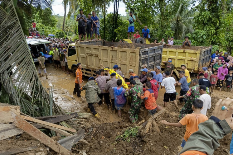 This handout picture taken and released on March 8 2024 by the National Disaster Mitigation Agency (BNPB) shows rescue personnel working at the scene of a landslide in Padang Pariaman, West Sumatra, following days of heavy rain across the province. 