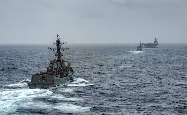 This handout photo courtesy of US Navy and made available on July 24, 2021 shows (L to R) guided-missile destroyer USS Halsey (DDG 97), French navy frigate FS Languedoc (D653), and aircraft carrier USS Ronald Reagan (CVN 76) steaming in formation in the Arabian Sea. 