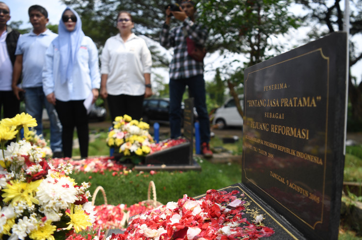 Trisakti University alumni and academia pay respects at the graves of Elang Mulia Lesmana and Herry Hartanto at the public cemetery in Tanah Kusir, Jakarta on May 12, in commemoration of their deaths in the 1998 riots.