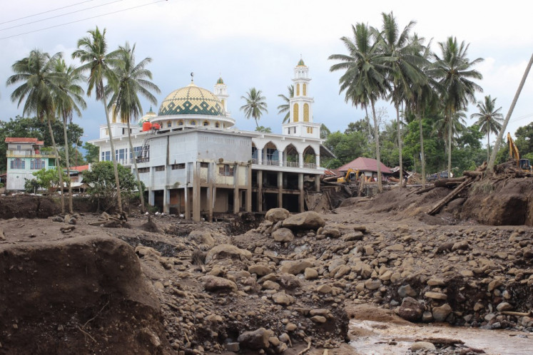 A mosque is seen past mud and debris following deadly flash floods and cold lava flow in Tanah Datar, West Sumatra, on May 13, 2024. The death toll from flash floods and cold lava flow from a volcano in western Indonesia over the weekend has risen to 44 with 15 more missing, officials said on May 13. 