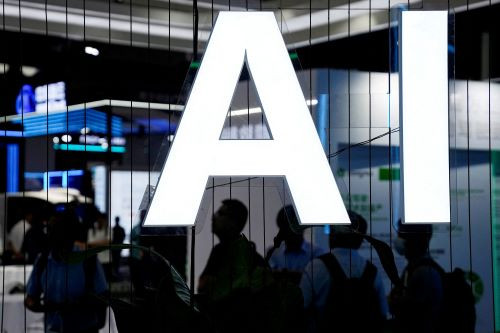 Driving power: Visitors are silhouetted on July 6, 2023 behind a sign for artificial intelligence at the World Artificial Intelligence Conference (WAIC) in Shanghai, China.