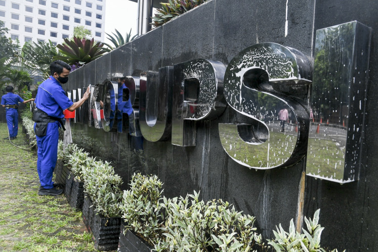 Workers clean signage on April 25, 2024 at the Jakarta headquarters of the Corruption Eradication Commission (KPK).