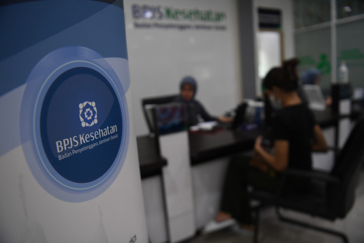 A Healthcare and Social Security Agency (BPJS Kesehatan) official helps a patient on May 14, 2024, at the agency's South Jakarta office.