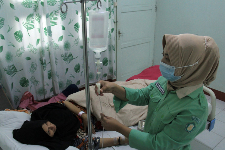 A nurse checks on an intravenous (IV) drip for a patient at the Yarsi general hospital in Pontianak, West Kalimantan, on May 14, 2024.