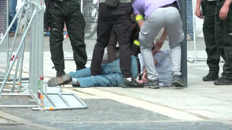 This image taken from video footage obtained by AFPTV shows security personnel apprehending a suspected gunman (C/GROUND) after Slovakia's Prime Minister was shot in Handlova on May 15, 2024. Slovakia's Prime Minister Robert Fico was battling life-threatening wounds after officials said he was shot multiple times in an assassination attempt condemned by European leaders.