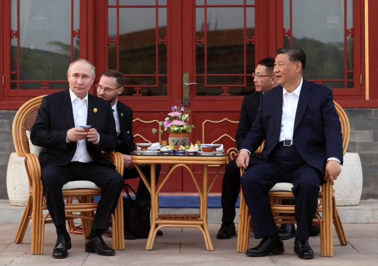 In this pool photograph distributed by the Russian state agency Sputnik, Russia's President Vladimir Putin and China's President Xi Jinping hold an informal meeting at Zhongnanhai leadership compound in Beijing on May 16, 2024. 