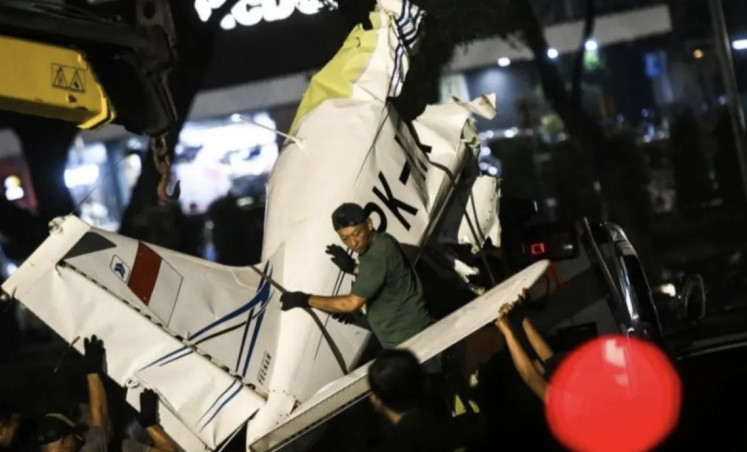 Workers load the wreckage of a light aircraft that crashed in Bumi Serpong Damai (BSD), Banten, onto a truck on May 19, 2024.