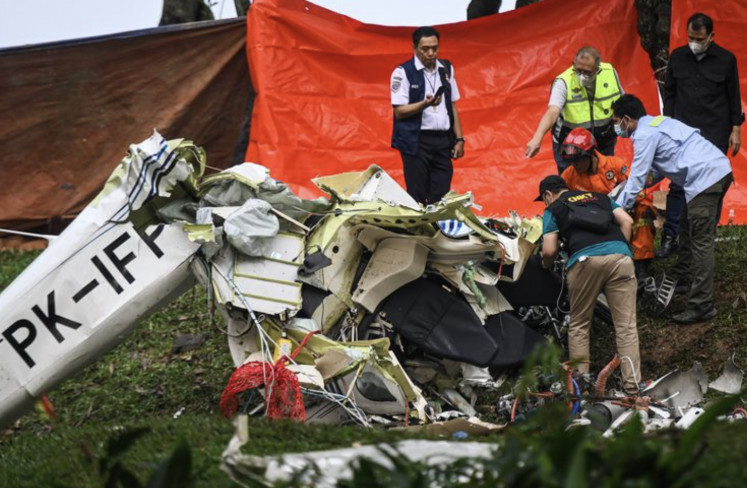 Investigators from the National Transportation Safety Committee (KNKT) sift through the wreckage of a light aircraft that crashed on May 19, 2024 in South Tangerang, Banten.
