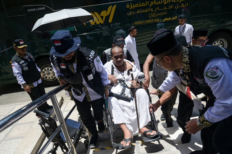 Indonesia haj management committee (PPIH) officials escort a pilgrim upon his arrival at a hotel in Mecca, Saudi Arabia, on May 20, 2024. More than 56,000 Indonesian pilgrims had arrived in the Middle Eastern country as of May 20 to go on the month-long pilgrimage.