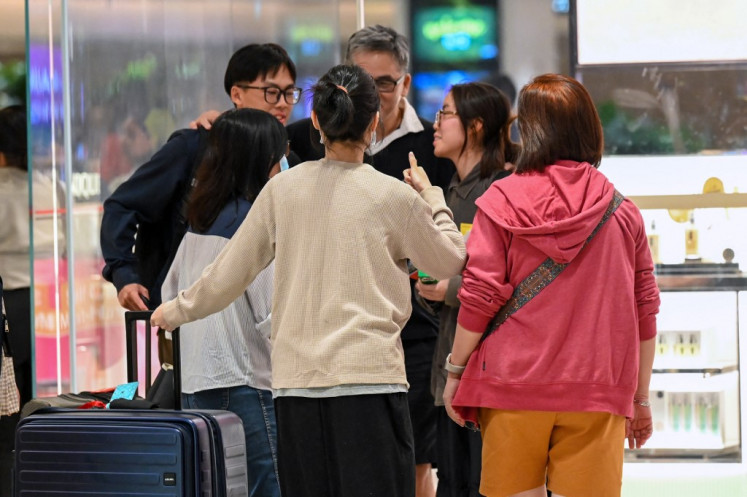 Passengers of Singapore Airlines flight SQ321 from London to Singapore, which made an emergency landing in Bangkok, greet family members upon arrival at Changi Airport in Singapore on May 22, 2024. 