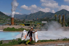 Harnessing nature: A worker carries sacks of manure on Aug. 19, 2020 at a farm near the geothermal well belonging to PT Geo Dipa Energi at Dieng Plateau in Banjarnegara regency, Central Java.