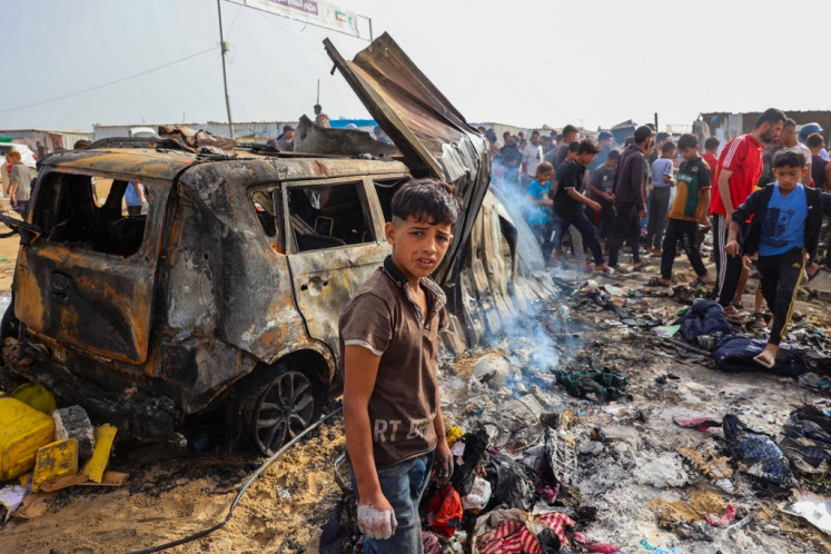 Palestinians gather on May 27, 2024, at the site of an Israeli strike on a camp area housing internally displaced people in Rafah, Palestine, amid ongoing battles between Israel and the Palestinian Hamas militant group. 
