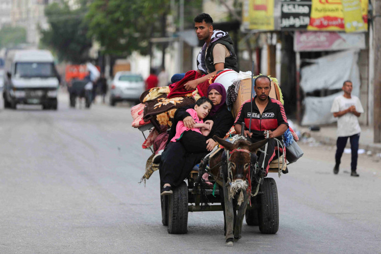 Palestinians travel in a donkey-drawn cart loaded with their belongings as they flee Rafah due to an Israeli military operation, in Rafah, in the southern Gaza Strip, May 28, 2024.