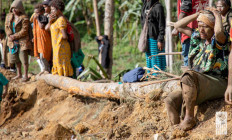 Onlookers react as people clear an area at the site of a landslide in Yambali village, Enga province, Papua New Guinea, May 27, 2024.  