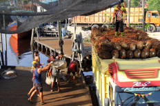 Workers load oil palm fresh fruits bunches (FFBs) onto a truck on May 23, 2024, at the Sungai Mesjid Port in Dumai, Riau. Indonesia, the world’s largest palm oil producer, has been looking to use biomass to reduce costly fuel imports.