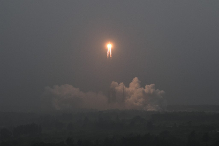 A Long March 5 rocket, carrying the Chang'e-6 mission lunar probe, lifts off as it rains at the Wenchang Space Launch Centre in southern China's Hainan Province on May 3, 2024.