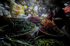 Weakening rupiah: A shopkeeper at a grocery stall attends to customers on June 1, 2024, at Rangkasbitung Market in Lebak, Banten. Prices have risen for several staple foods, including shallots from Rp 30,000 (US$1.77) to Rp 45,000 per kilogram and red chilis from Rp 30,000 to Rp 50,000 per kg.