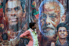 A man stands on June 4, 2024, in front of a poster featuring India's Prime Minister Narendra Modi and Bharatiya Janata Party (BJP) election candidate K.Annamalai, outside its party office in Chennai, India.