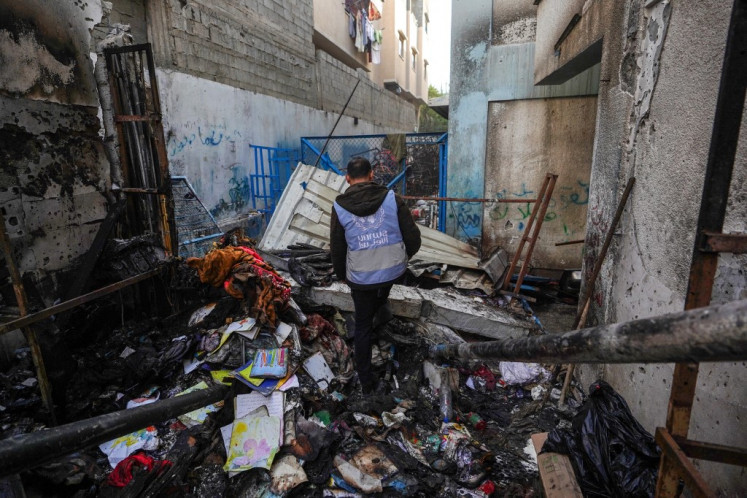 A UNRWA personnel checks a burnt area at a school housing displaced Palestinians that was hit during the ongoing conflict between Israel and the militant group Hamas, in Nuseirat in the central Gaza Strip on May 17, 2024.
