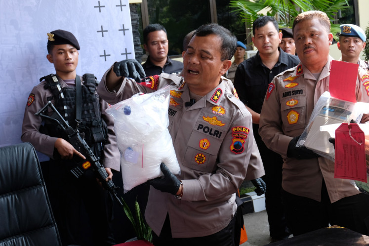 Central Java Police chief Insp. Gen. Ahmad Luthfi (center) shows a piece of evidence during a press briefing about a drug bust at the Magelang Police headquarters in Central Java on May 21, 2024.