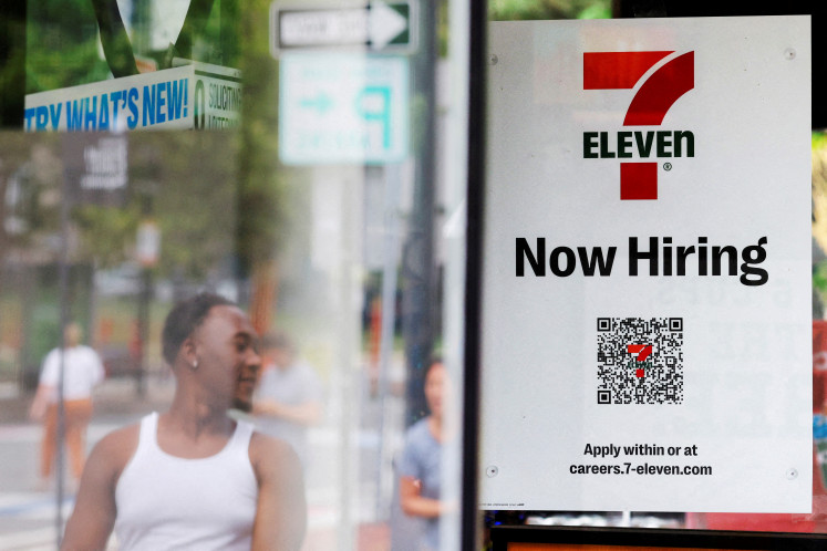 A 7-Eleven convenience store has a sign in the window reading “Now Hiring“ in Cambridge, Massachusetts, US, on July 8, 2022.