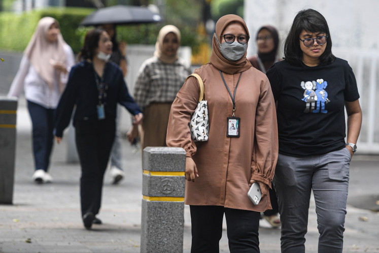 Office workers walk along Jl. Sudirman in downtown Jakarta on May 30, 2024.
