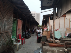 Transitory life: A person sweeps on June 5, 2024 in front of the temporary houses sheltering former residents of Kampung Bayam on Jl. Tongkol 10, Tanjung Priok, North Jakarta. Around 35 families returned to the shelters after they were evicted in May from an apartment complex next to Jakarta International Stadium.
