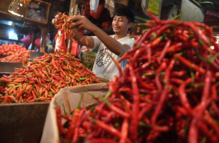 A chili seller sorts fresh picks for his display at a stall in Senen Market, Central Jakarta, on
June 10, 2024.