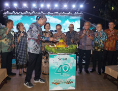 Sequis Life President Director & CEO Ted Margono (third left) cuts a tumpeng, a ceremonial dish made of yellow rice, at the 40th anniversary celebration of the life and health insurance company to the applause of other Sequis Life executives, including President Commissioner and Shareholder Representative Husodo Angkosubroto (center) and Managing Executive Officer and Head of Global Business Minoru Kimura (fourth right), along with other members of the directorial board and management team.