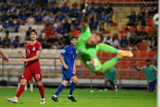 Singapore's goalkeeper Hassan Sunny (right) jumps to try to stop the shot by Thailand's Poramet Arjvirai (centre left) during the 2026 FIFA World Cup AFC qualifiers football match between Thailand and Singapore at Rajamangala Stadium in Bangkok on June 11, 2024. 